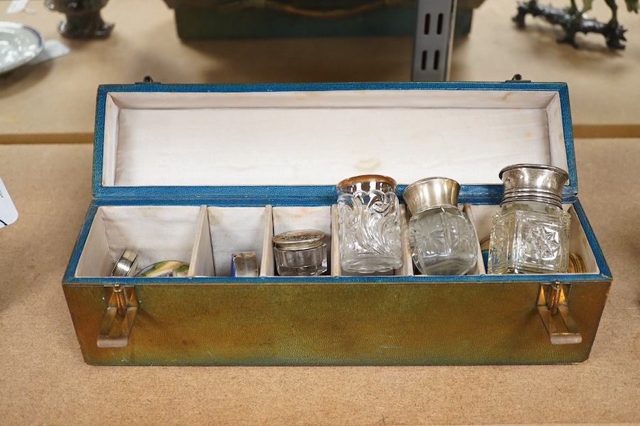 A green leather sectioned box containing a collection of cut glass, silver mounted and silver plated boxes and jars, some with guilloche enamel lids, largest 7cm high